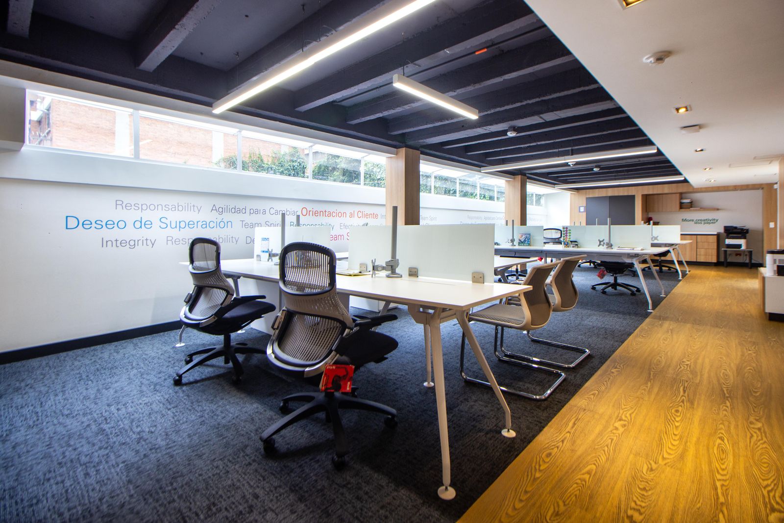 Bright, spotless modern office workspace with clean desks and glass partitions