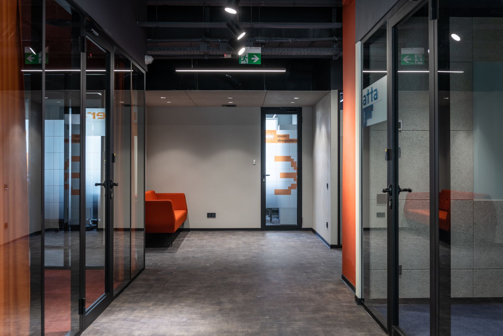 Clean, modern office corridor with glass-walled meeting rooms